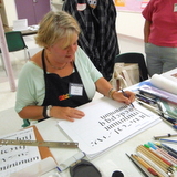 Penne Tompkins demonstrating calligraphy