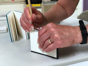 Jill Abilock demonstrating how to punch cover holes for coptic binding
